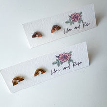 Load image into Gallery viewer, gold and silver rainbow-shaped earrings on white cards with 'Lilac and Rose' branding.