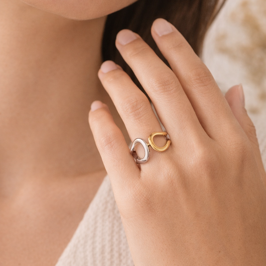 Close-up of a hand wearing a gold ring with a unique design.