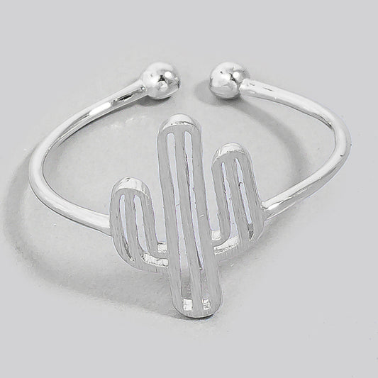 A silver-toned open cuff ring featuring a stylized cactus design in the center, photographed on a neutral light gray background.