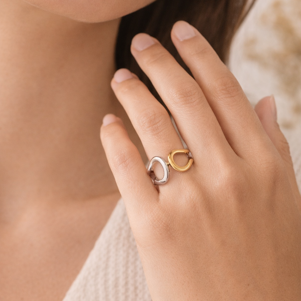 Close-up of a hand wearing a gold ring with a unique design.