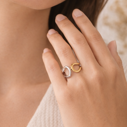 Close-up of a hand wearing a gold ring with a unique design.