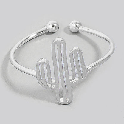 A silver-toned open cuff ring featuring a stylized cactus design in the center, photographed on a neutral light gray background.