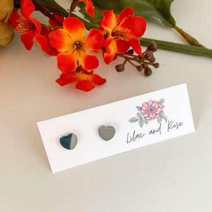 Silver heart stud earrings on display card
