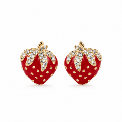 A pair of strawberry-shaped stud earrings with glossy red enamel bodies, gold-tone stems and dotted details, and clear rhinestone-encrusted leaves, shown on a plain white background.